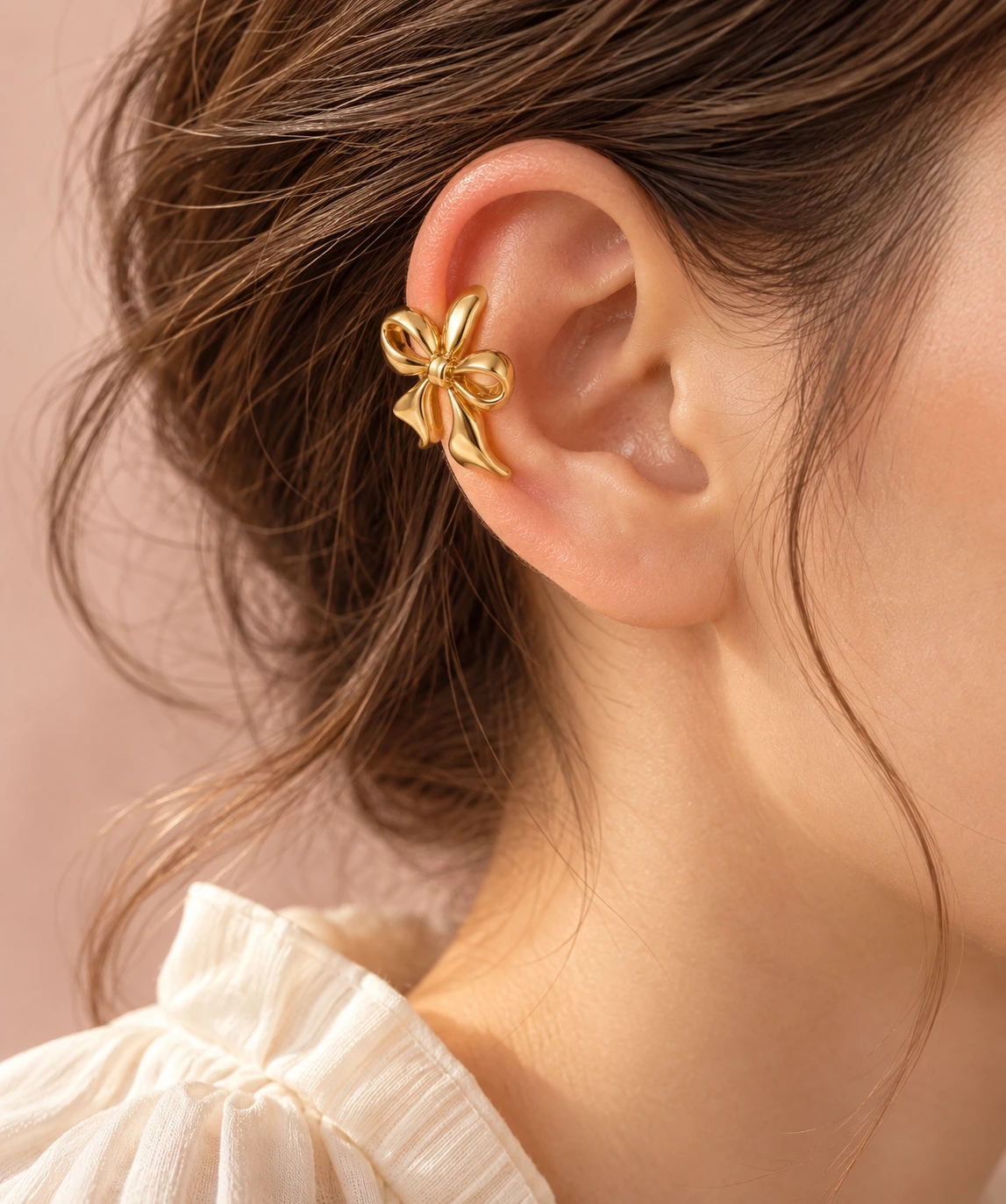 A single gold bow ear cuff styled on the outer ear